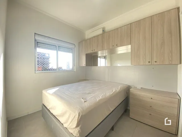 Quarto com janela e armário de madeira.