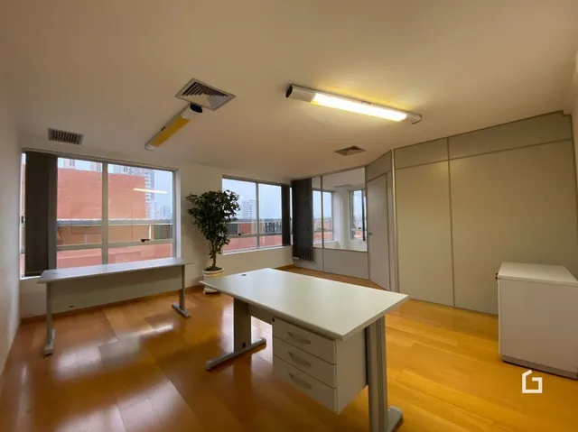 Ambiente interno de uma sala com piso de madeira e luminária de teto.