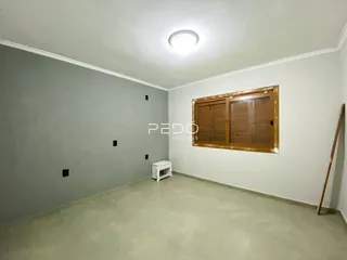 Ambiente interno de uma sala com paredes cinzas e piso claro.