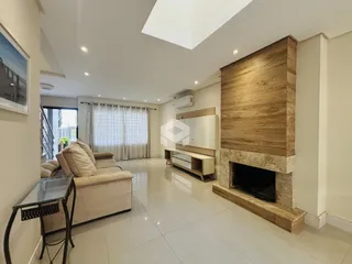 Sala de estar com lareira e piso de porcelanato claro.