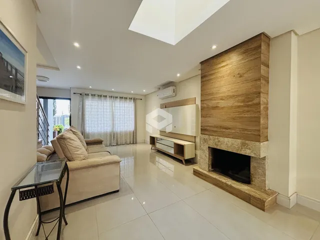 Sala de estar com lareira e piso de porcelanato claro.