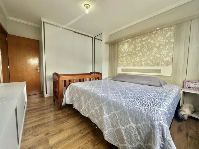 Quarto com cama de madeira e piso de madeira clara.