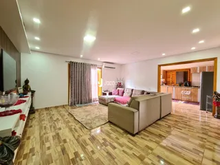 Sala de estar com piso de madeira clara e sofá.