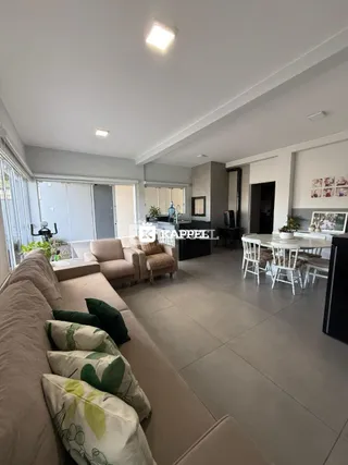 Sala de estar com sofá e área de jantar em um apartamento moderno.