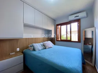 Quarto com armários embutidos e janela de madeira.