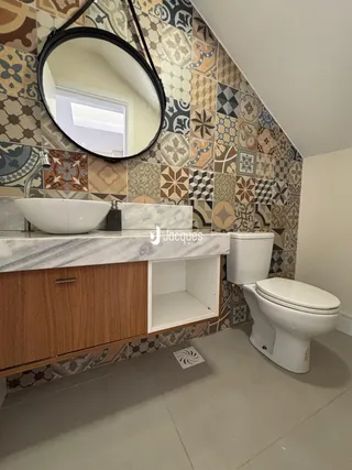 Foto de um banheiro com bancada de mármore e revestimento de parede decorativo.