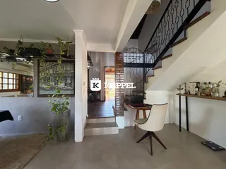 Vista interna de uma sala com escadaria e decoração.