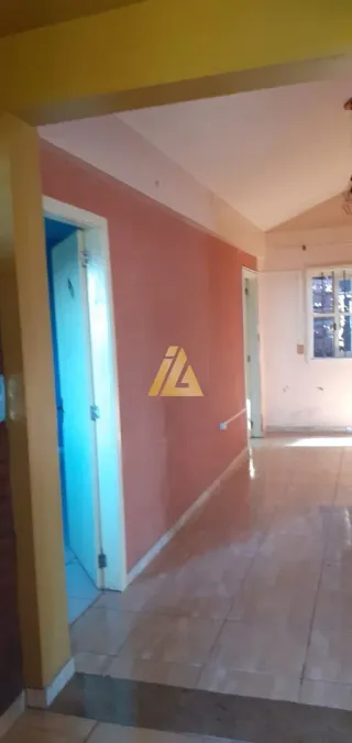 Corredor interno com paredes em tons de laranja e piso de cerâmica.