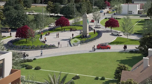 Vista externa de um jardim com árvores e áreas pavimentadas.