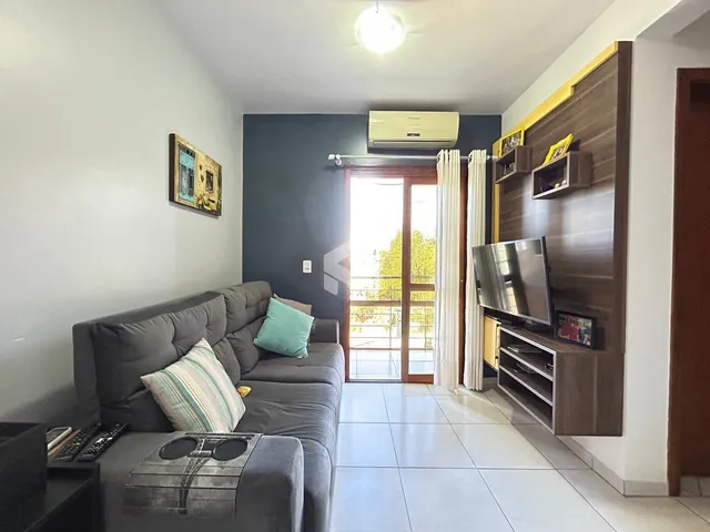 Sala de estar com sofá e painel de madeira em um imóvel no Brasil.