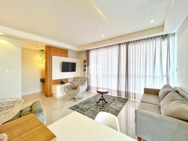 Sala de estar moderna com grandes janelas e decoração neutra.