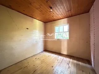 Foto do interior de uma sala com piso de madeira e teto de madeira.