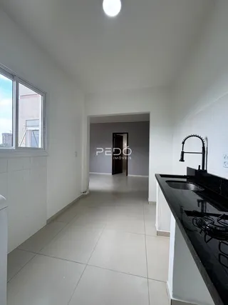 Vista do corredor interno de uma residência com paredes brancas e piso claro.