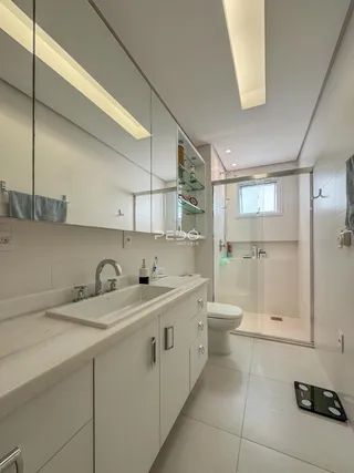 Banheiro moderno com bancada e box de vidro.