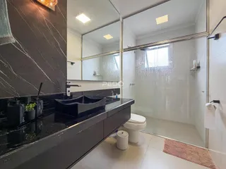 Banheiro moderno com piso de cerâmica e box de vidro.