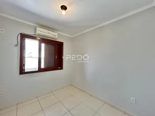 Ambiente interno de uma sala com piso cerâmico e janela em Lajeado.