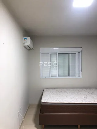 Quarto com cama e janela em ambiente interno.