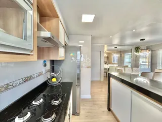 Cozinha moderna com armários de madeira e bancadas escuras.
