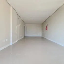 Corredor interno de uma residência com paredes brancas e piso claro.