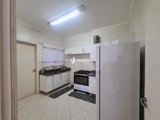 Cozinha com armários brancos e piso de cerâmica.