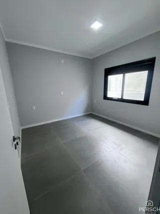 Foto de um cômodo interno com paredes brancas e piso claro.
