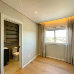 Quarto com piso de madeira e janela visível.