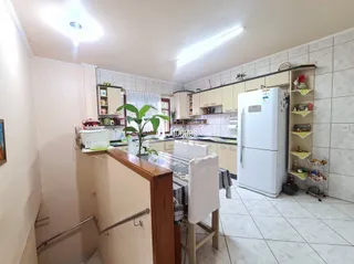 Foto de uma cozinha com armários brancos e revestimento de cerâmica.
