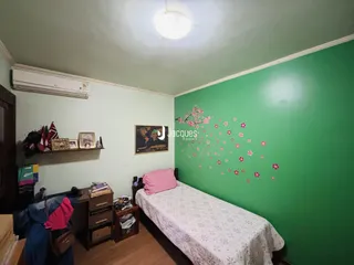 Quarto com parede verde e cama de casal em um imóvel no Brasil.