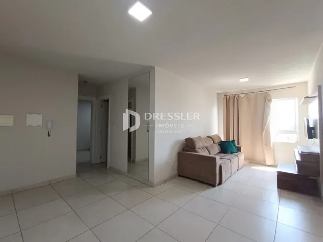 Sala de estar com piso de cerâmica e sofá claro.