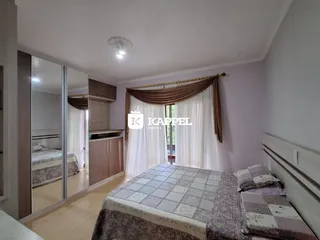 Quarto com cama de casal e cortinas claras.