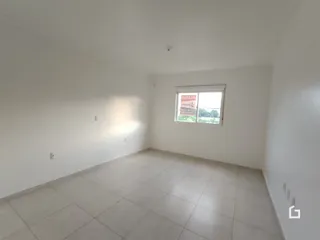 Imagem de uma sala ampla com piso de cerâmica e paredes brancas.