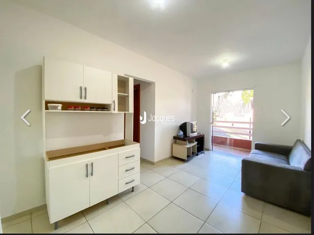 Ambiente interno com piso de cerâmica e armários brancos.
