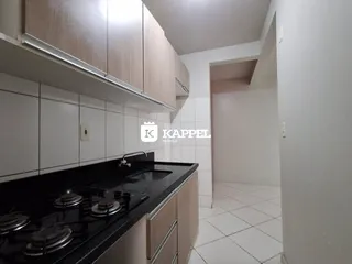 Foto de uma cozinha com armários superiores e bancada escura.