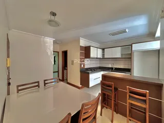 Vista de uma sala de jantar com mesa e cadeiras em um imóvel no Brasil.