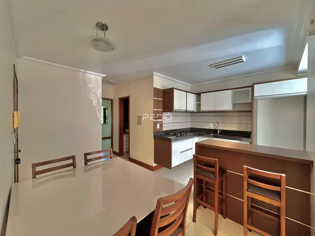 Vista de uma sala de jantar com mesa e cadeiras em um imóvel no Brasil.