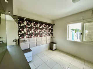 Quarto com cabeceira floral e piso de cerâmica em Lajeado.