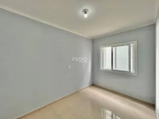 Uma sala de estar com paredes cinzas e piso claro.