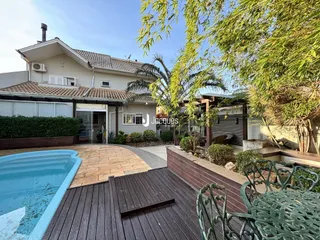 Vista da fachada de uma casa com piscina e deck em Lajeado.