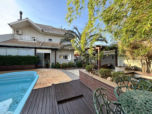 Vista da fachada de uma casa com piscina e deck em Lajeado.