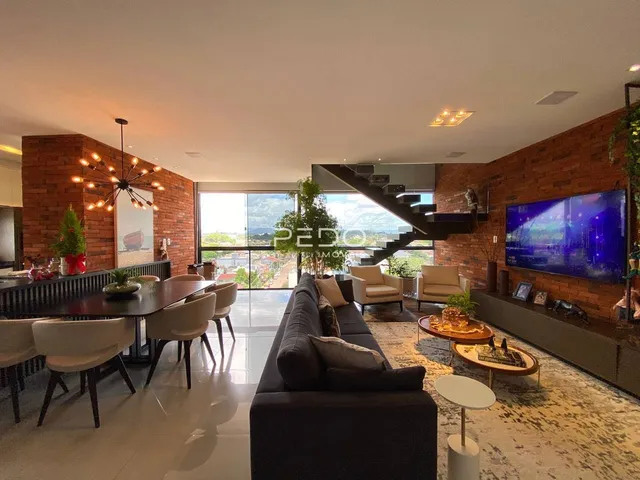Sala de estar ampla com paredes de tijolo aparente e vista para o exterior.