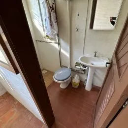Foto de um banheiro interno mostrando um vaso sanitário e uma pia.