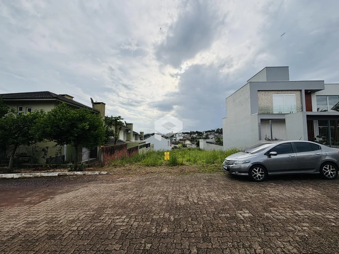 Vista externa de uma propriedade em Lajeado, Brasil com área gramada e terreno aberto.