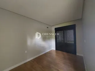 Ambiente interno com piso de madeira e porta escura.