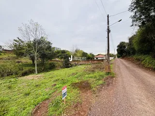 Vista da propriedade rural com estrada de terra e vegetação ao redor.