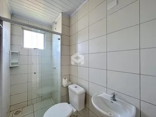 Foto de um banheiro com revestimento cerâmico e box de vidro.