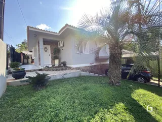 Fachada de uma casa em Lajeado, Brasil, com jardim gramado e palmeira.