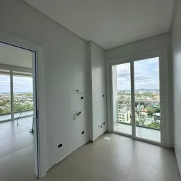 Sala de estar com grandes janelas que oferecem uma vista da cidade.