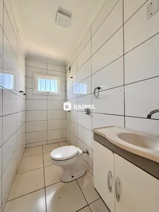 Banheiro com piso de cerâmica e vaso sanitário branco.