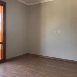 Foto de uma parede interna com piso de madeira em um ambiente vazio.
