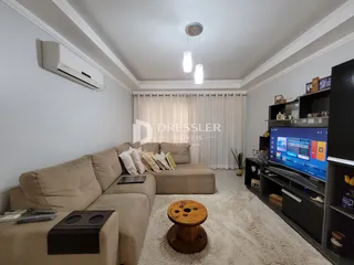 Sala de estar com sofá e televisão em um apartamento.